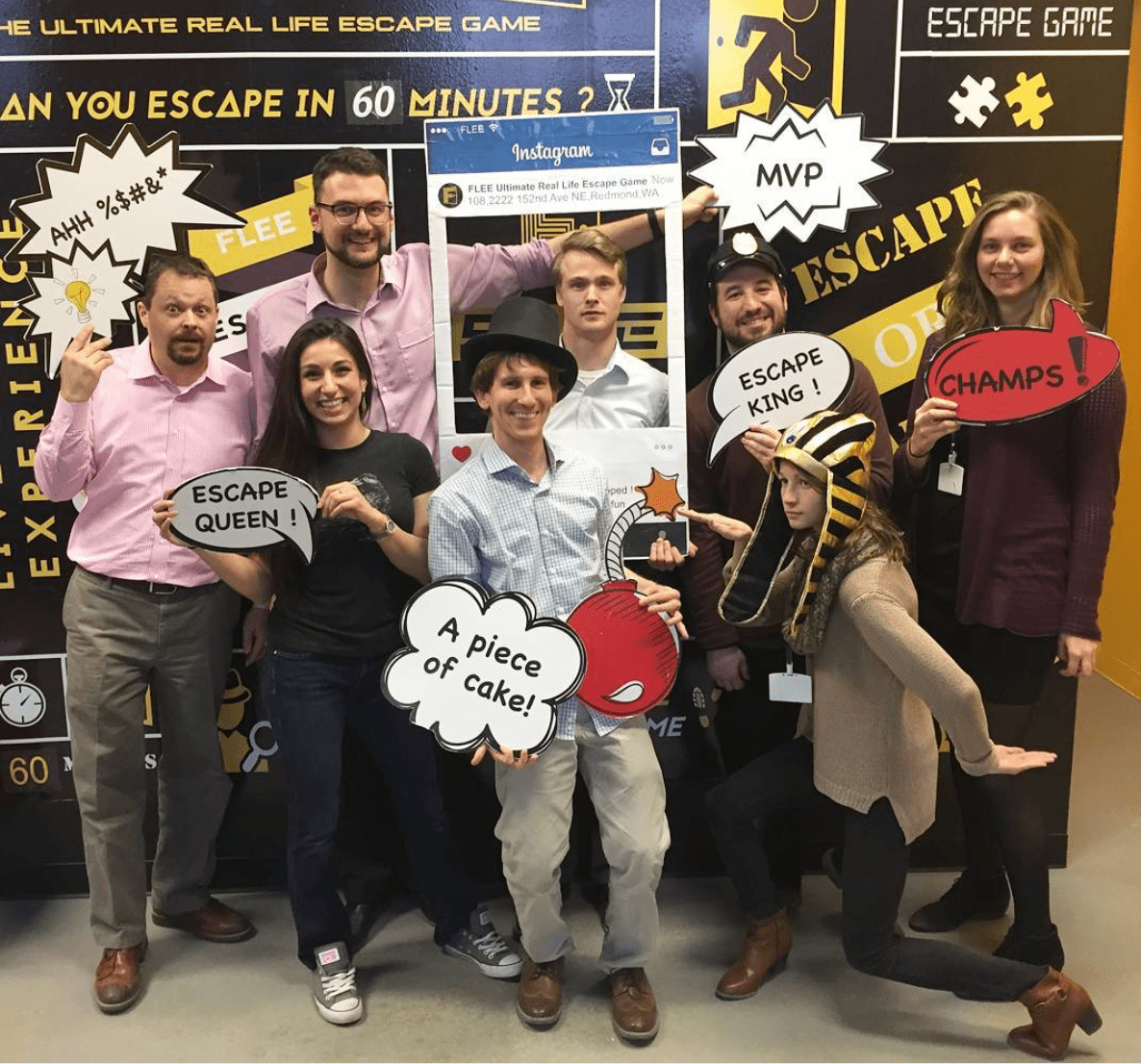 Group of people holding signs after completing an escape room